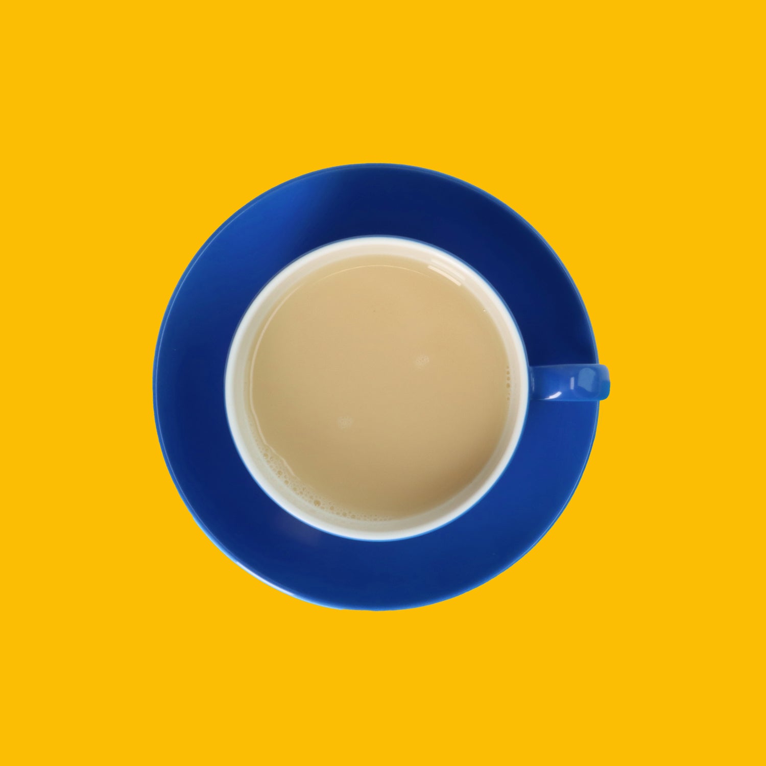 Drinkmich Bananengeschmack Haferdrink zum Selbermixen Serviervorschlag in blauer Kaffeetasse von oben auf gelbem Hintergrund