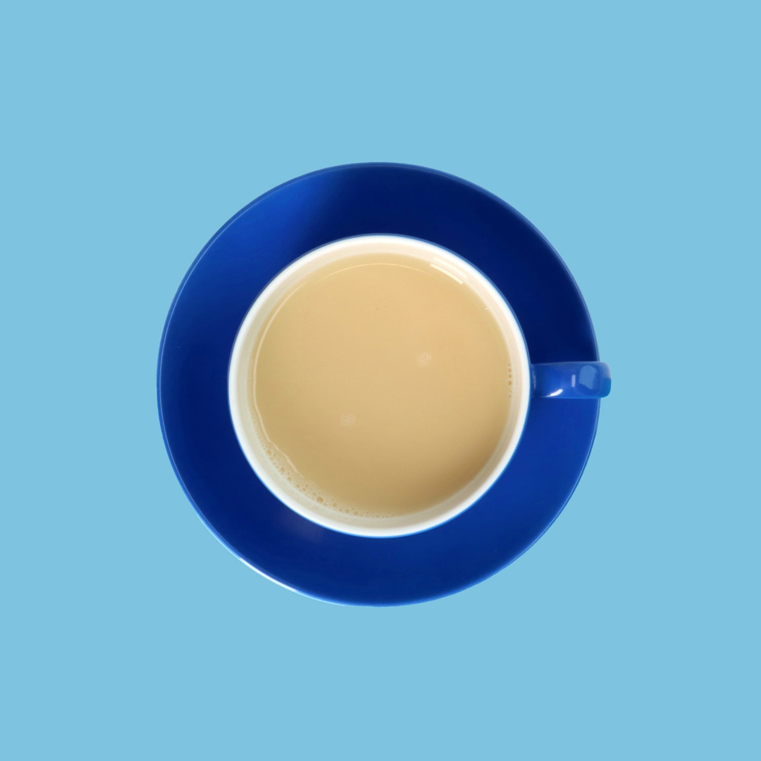 Drinkmich Hafermilchpulver mit Calcium Serviervorschlag in dunkelblauer Porzellantasse vor hellblauem Hintergrund