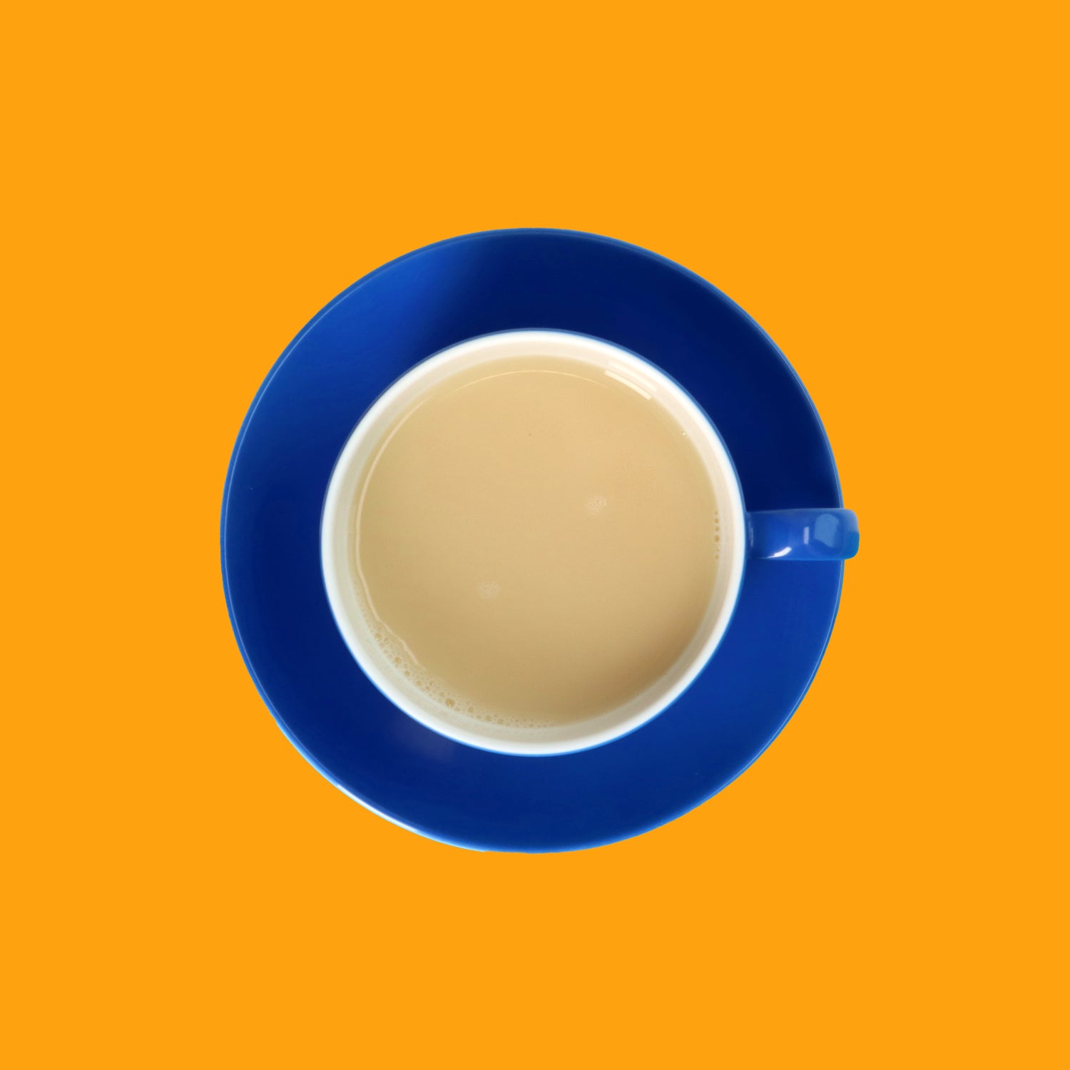 Drinkmich Hafermilchpulver Klassik Haferdrink zum Selbermixen Serviervorschlag in blauer Porzellantasse von oben vor orangem Hintergrund
